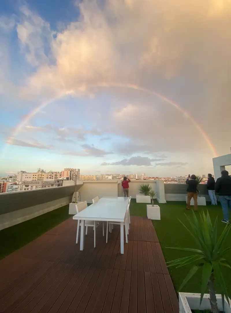 Terraço do escritório da Bluesoft em Lisboa com um arco-íris sobre a cidade